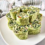Spinach dip pinwheels on a white platter.