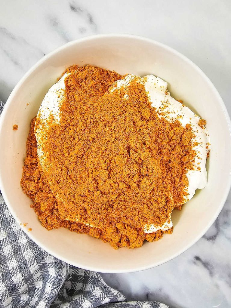 Sour cream and taco seasoning in a mixing bowl.