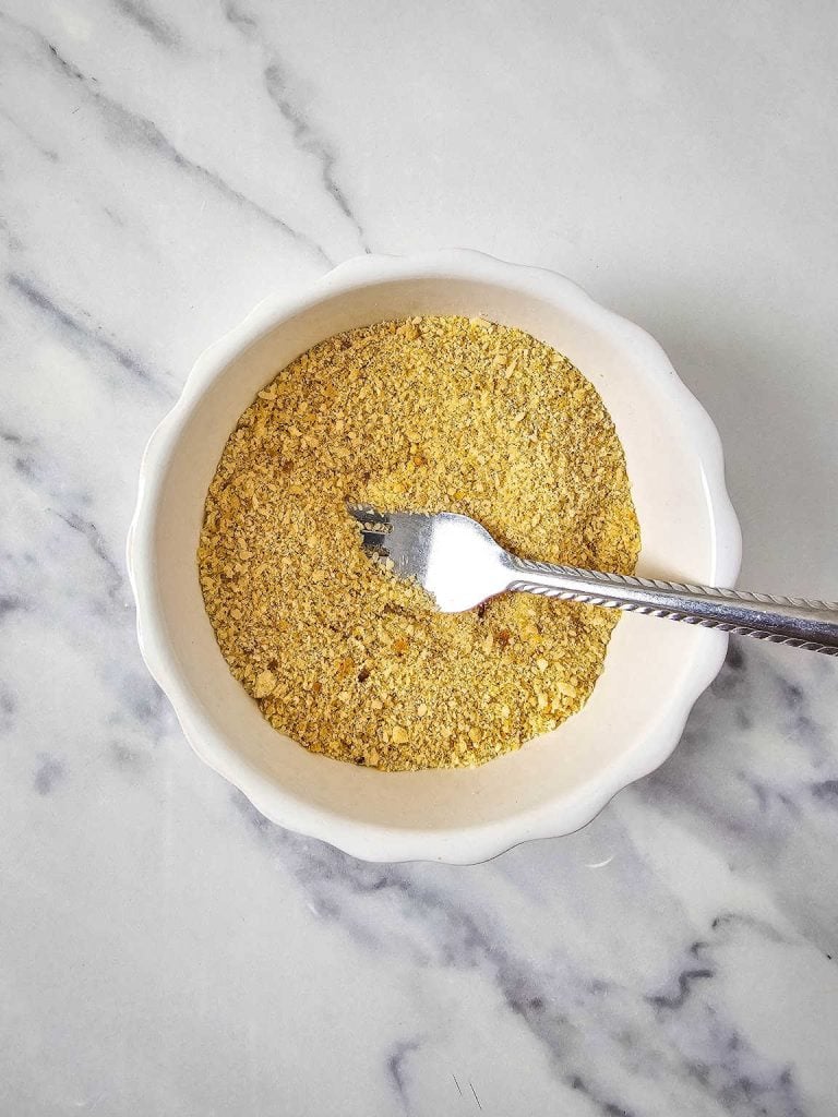 Mixture of breadcrumb and cheese, fork in a bowl.