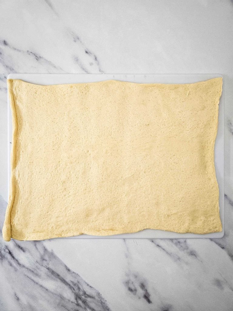 Crescent dough spread on a cutting board.
