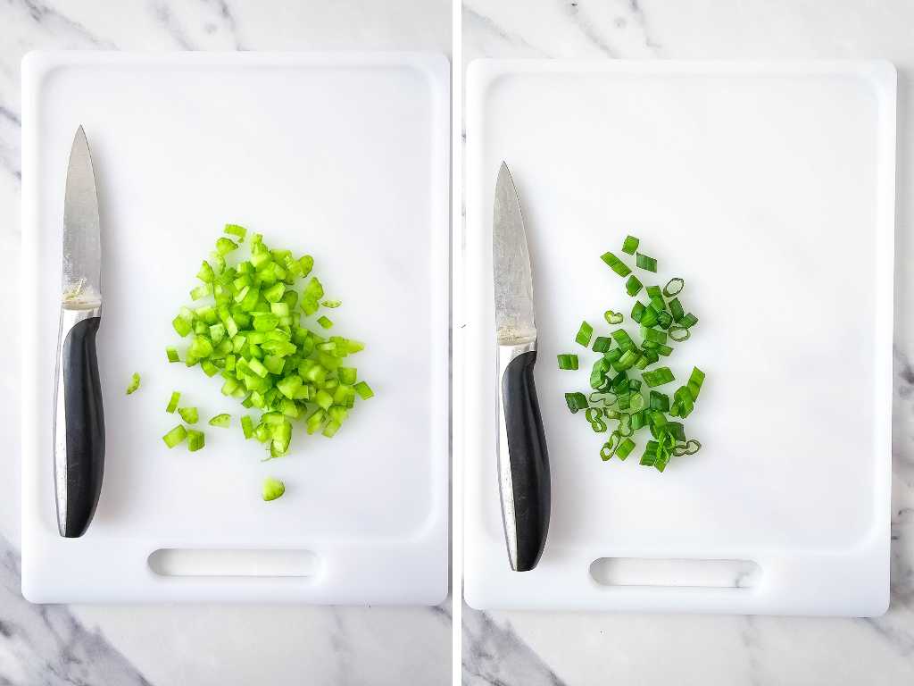 Chopped celery and green onion and knives on a white cutting board.