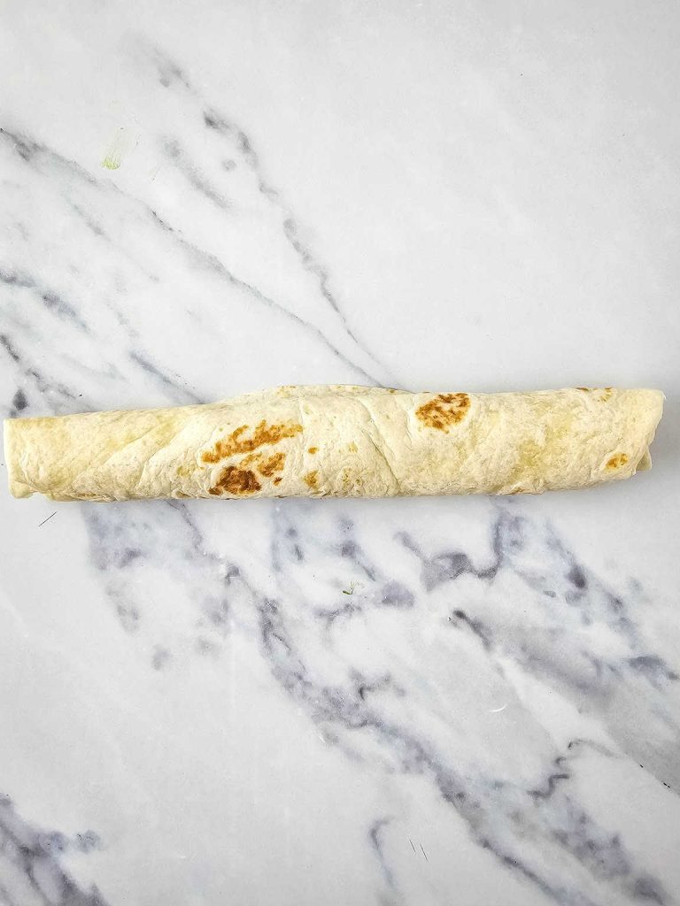 Chicken avocado salad pinwheels rolled into a log.