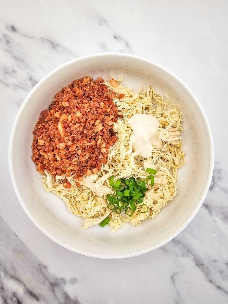 Chicken bacon ranch mozzarella wraps ingredients in a mixing bowl.