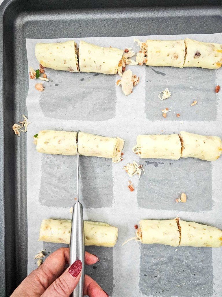 Cutting the chicken bacon ranch mozzarella wraps in half.