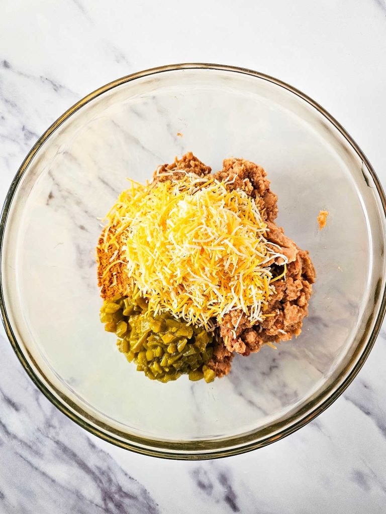 Texas trash dip ingredients in a mixing bowl.