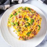 Jalapeno popper cheese ball on a white platter.