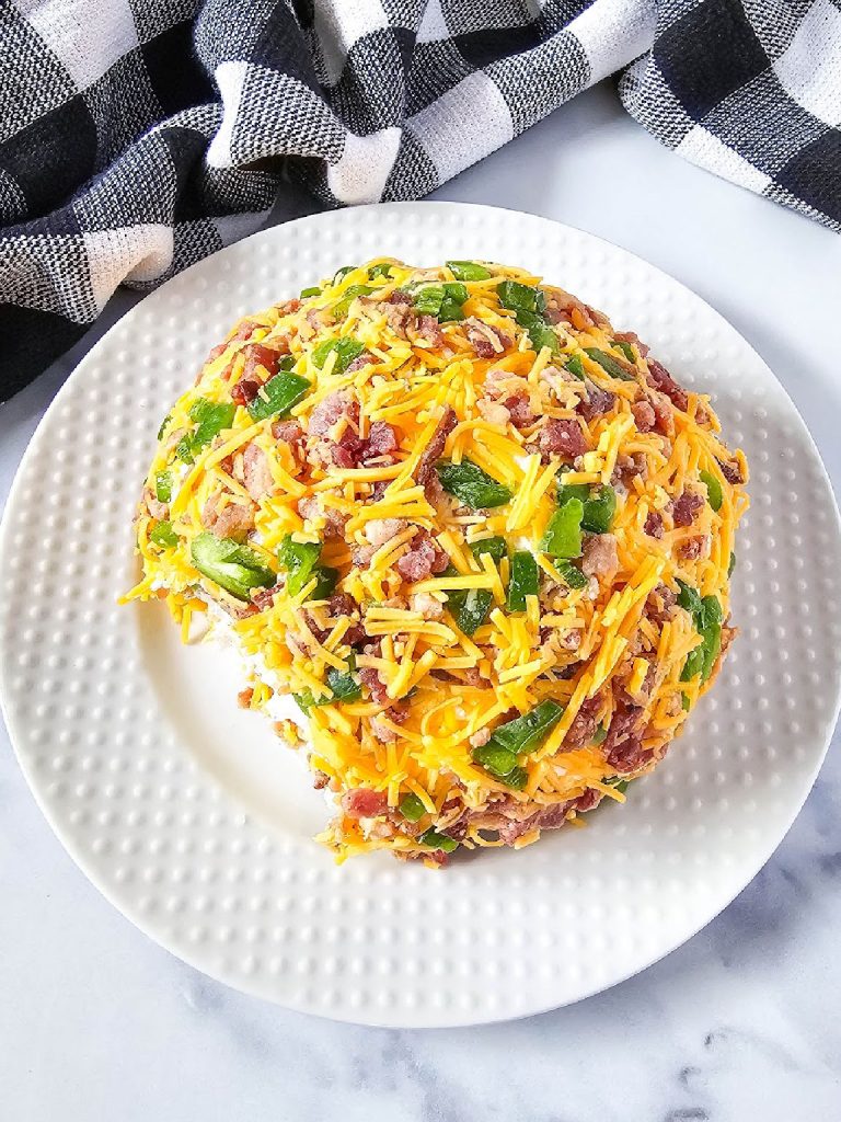 Jalapeno popper cheese ball on a white platter.