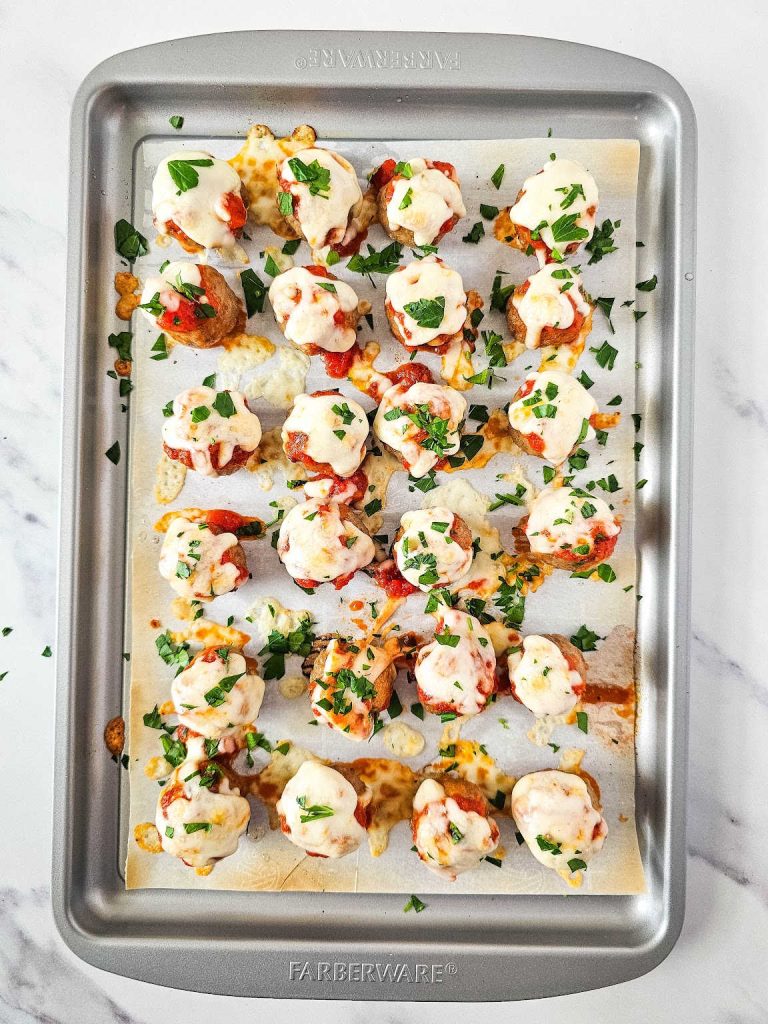 Broiled meatball marinara bites in a baking sheet.
