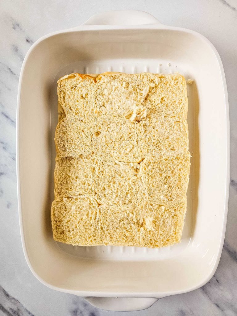 Bottom half of slider rolls in a white casserole dish.