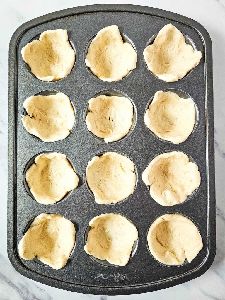Dough in 12-cavity muffin tin.