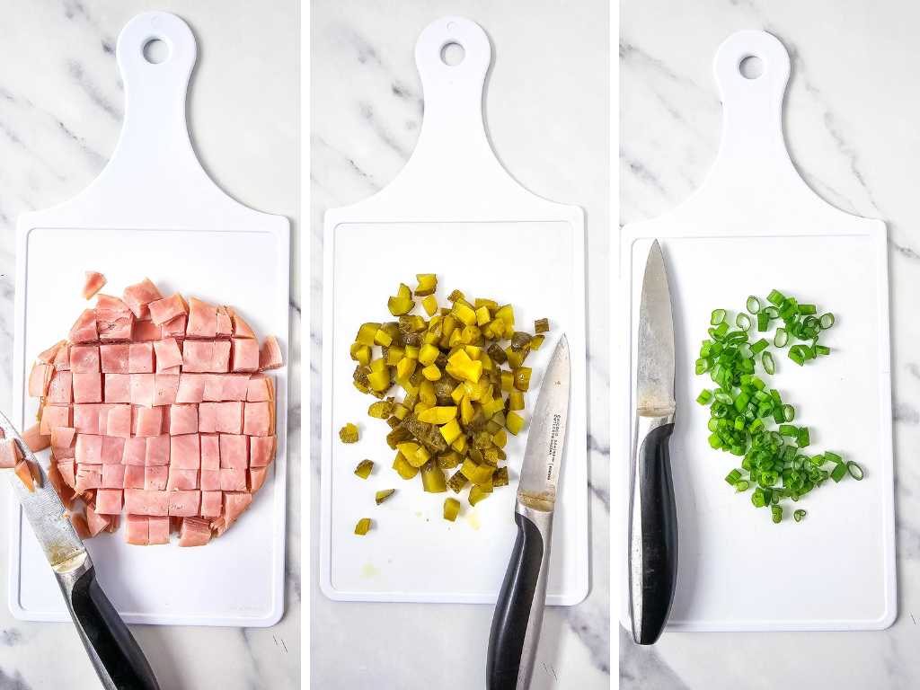 Chopped ham, dill pickles and green onions, knives on cutting boards.