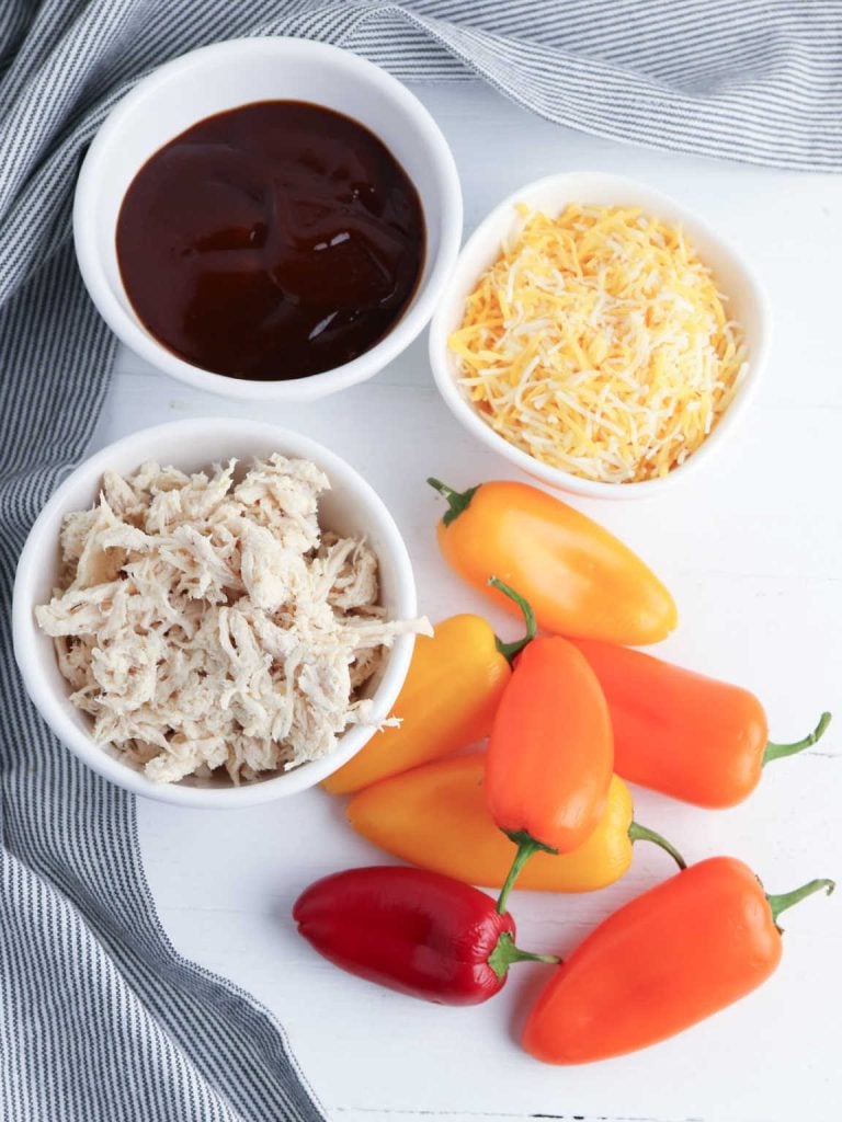 BBQ stuffed mini mini peppers ingredients. which include mini bell peppers, shredded chicken, BBQ sauce, shredded fiesta blend cheese.