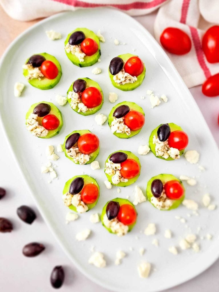 Greek salad bites on a white platter.